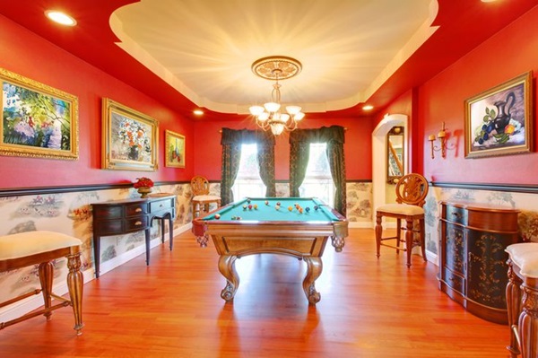 Red billiard luxury room with play pool and cherry hardwood.