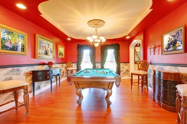 Red billiard luxury room with play pool and cherry hardwood.