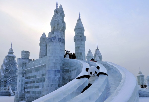 An employee wearing a panda costume slides down from an ice sculpture during the Harbin International Ice and Snow World festival in Harbin, Heilongjiang province, January 11, 2013. REUTERS/Sheng Li (CHINA - Tags: SOCIETY TRAVEL TPX IMAGES OF THE DAY)