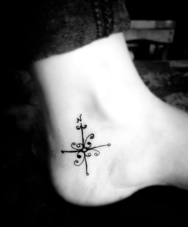 Tattoo of a cross done on the ankle minimalistic