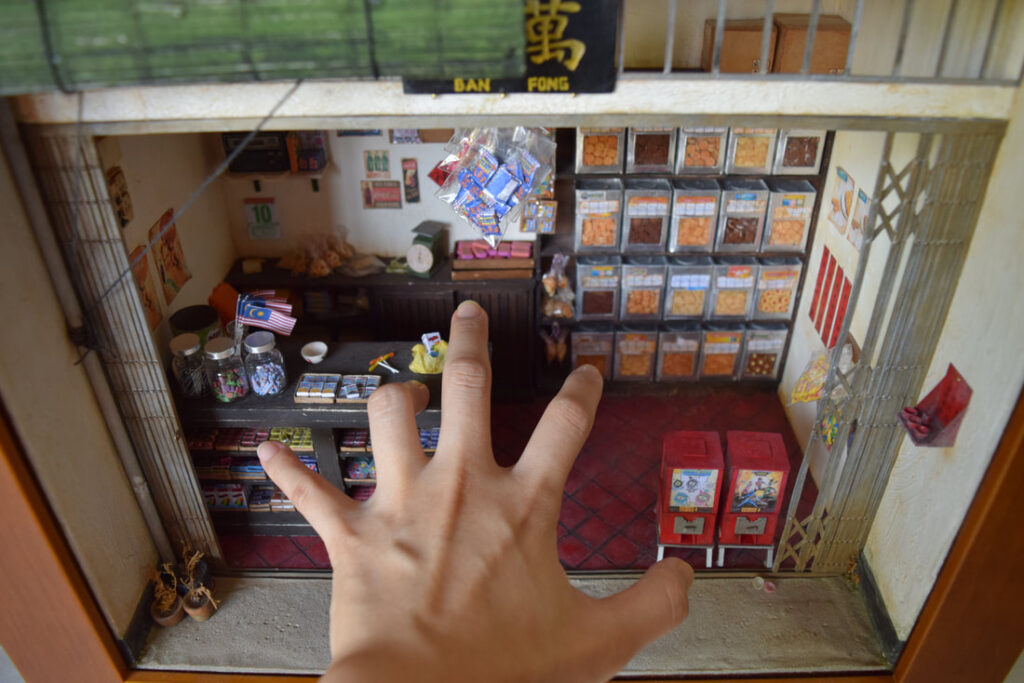 Miniature retro-style Malaysian provision shop by Pui Wan Lim, featuring lifelike dollhouse-scale goods, shelves, and nostalgic decor.